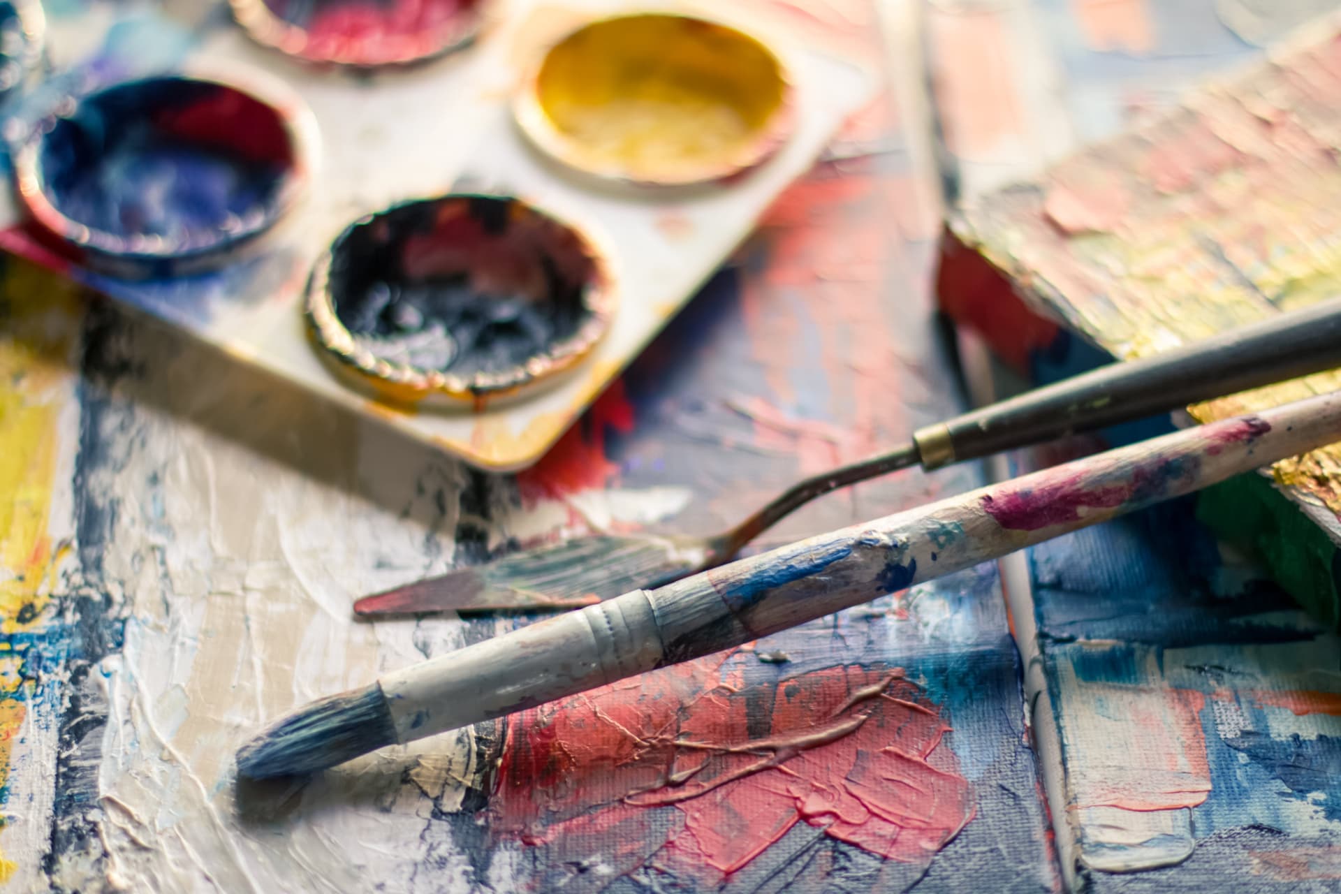 A painter's palette and brushes resting on a textured canvas